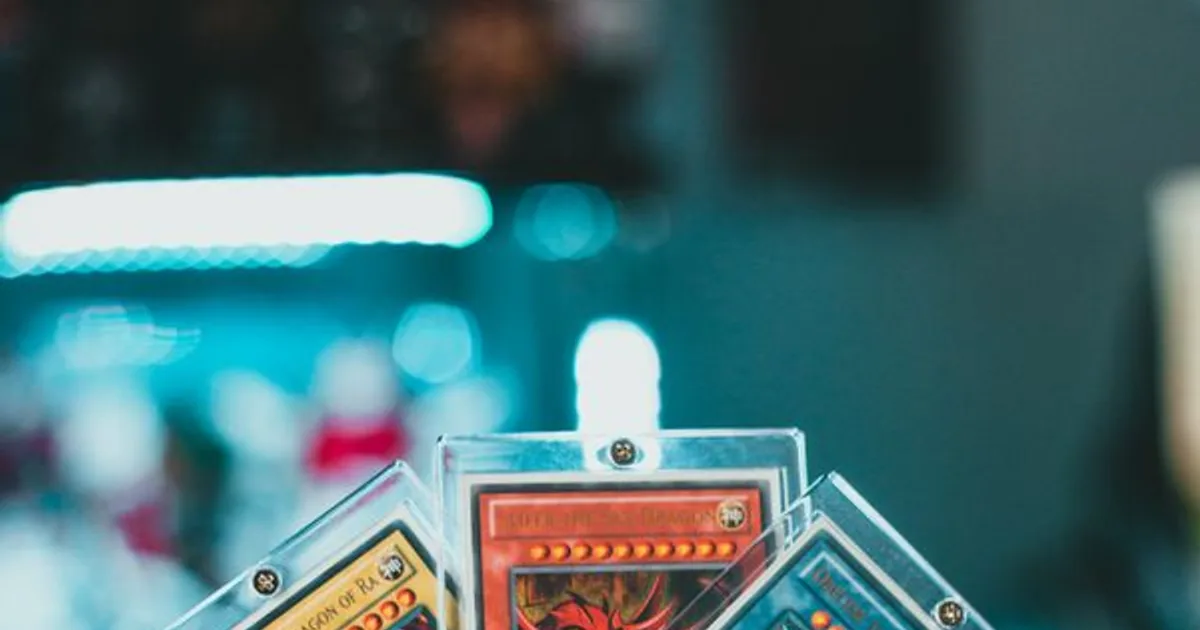 Hand holding collectible trading cards in protective cases