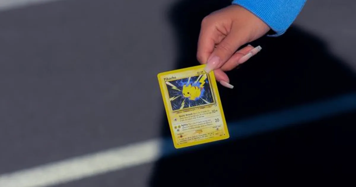 A trading card examined closely for authenticity under light