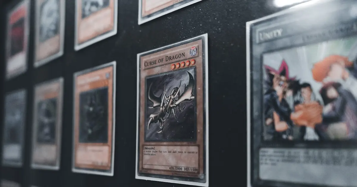 Cards from different TCGs in protective sleeves showing variety of art styles