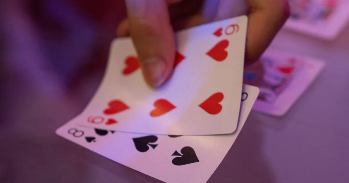 Trading card being held under direct light to check surface condition