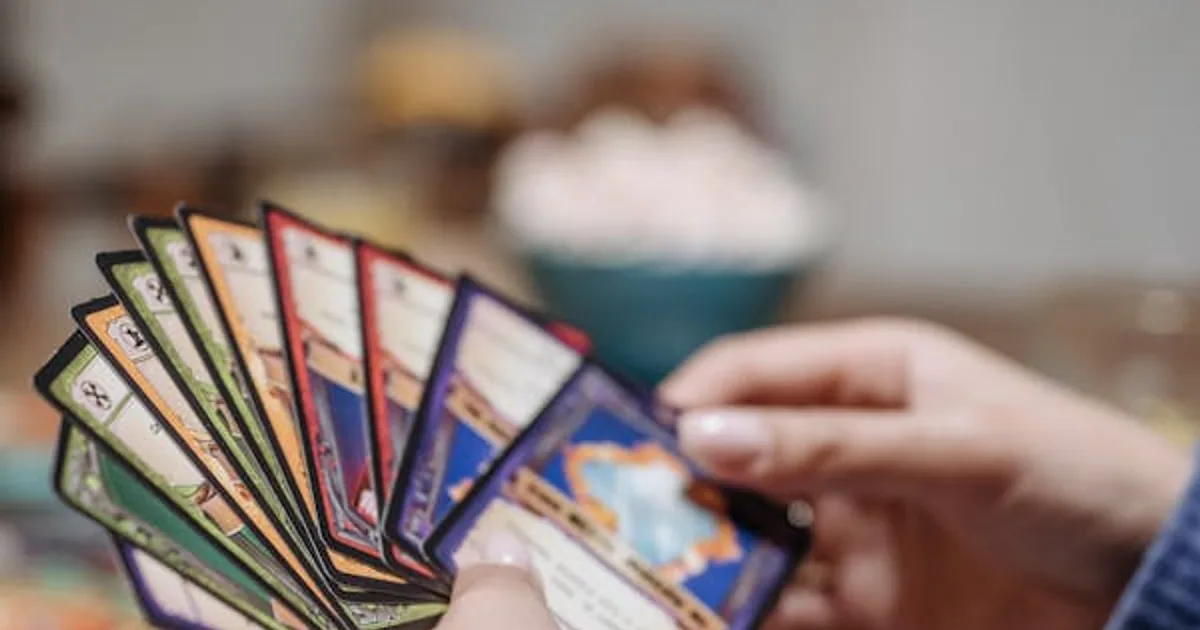 Hands holding a fan of trading cards during a trade